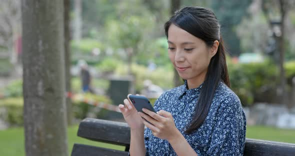 Woman use of mobile phone in the park