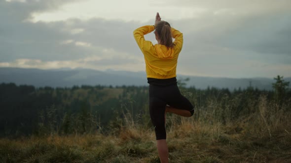 Fit Girl Exercising Yoga Pose in Mountains