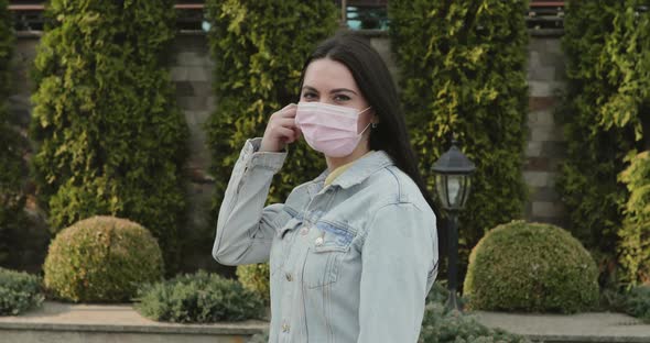 Portrait of Cured, Girl in Garden Undresses Medical Mask and Smiles at Camera