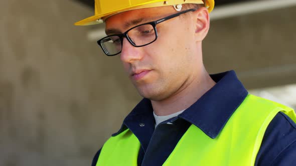 Builder in Helmet and Safety West with Tablet Pc