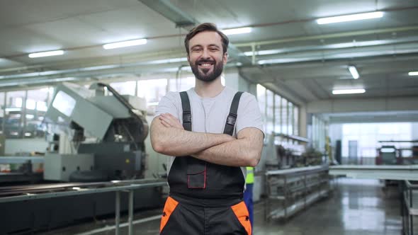 Portrait of Adult Employee Man 30s Wearing Working Overall Standing with Arms Crossed During Work in