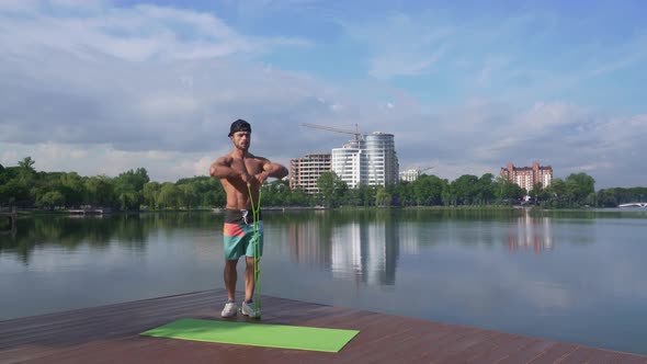 Sexy Fit Man Doing Exercises for Arms with Silicone Expander