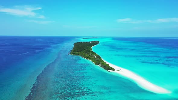 Daytime overhead clean view of a white sandy paradise beach and blue ocean background in hi res 4K