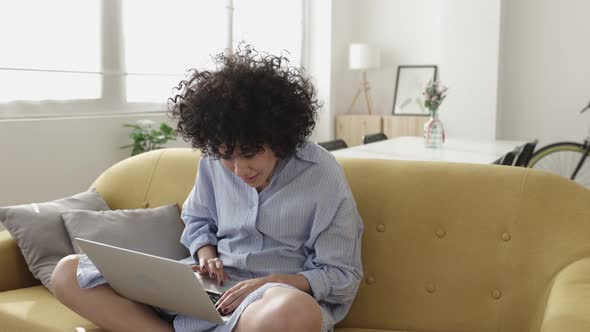 Young Adult Woman Using Laptop Computer Relaxing at Home