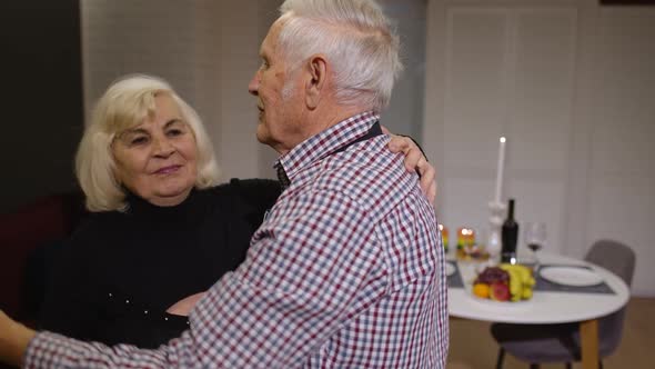 Senior Couple in Love Have Romantic Evening, Dancing Together in Kitchen, Celebrating Anniversary