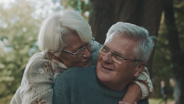 Happy Old Couple Hugging in Park. Senior Man Flirting with Elderly Woman. Romance at Old Age on