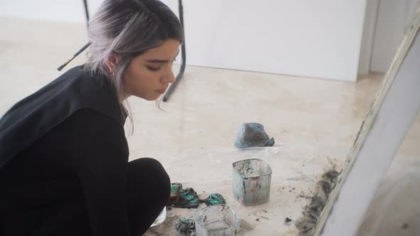 Latina Woman Artist Making An Abstract Painting On Canvas In Her Workshop - medium shot