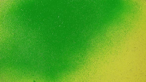 Painting Yellow Walls with Neon Green Paint Using Spray Can Closeup