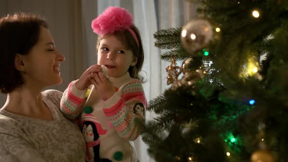 New Year. Mom With Her Little Daughter Decorate The Christmas Tree.