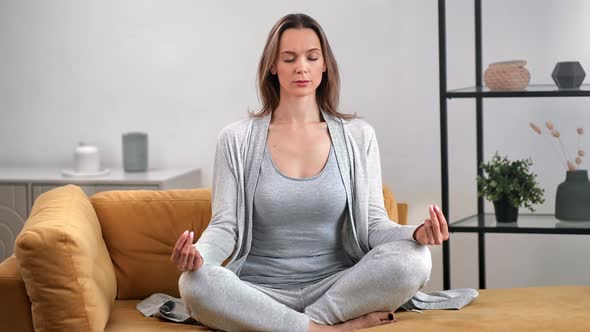 Pleasant Lady Practicing Morning Yoga Breathing Exercise in Lotus Position