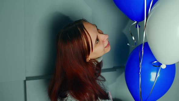 Young Woman with Air Balloons Near Wall