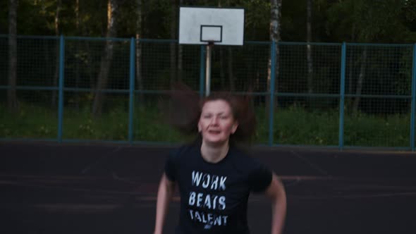 Woman Jumping Raising Her Hands Up on the Sports Ground Morning Exercises