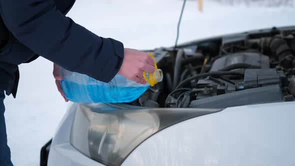 Closeup of Man Pours Washer Fluid in Tank of Car