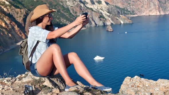 Attractive Stylish Travel Young Woman Taking Selfie Using Smartphone Posing on Top of Mountain