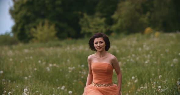 Portrait of Pretty Asian Woman Bride Running in Slow Motion on Summer Field