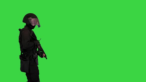 Swat Police Operator with Assault Rifle Walking By on a Green Screen Chroma Key