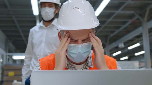 Engineer in Mask Having Headache Working at Laptop and Colleague Advising Him To Wear Eyeglasses