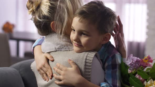 Closeup Cute Boy Felicitating and Hugging Mother