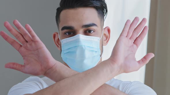 Closeup Arabic Ethnic Man in Medical Protective Mask Shows Stop Gestures Prohibits Crossing Arms