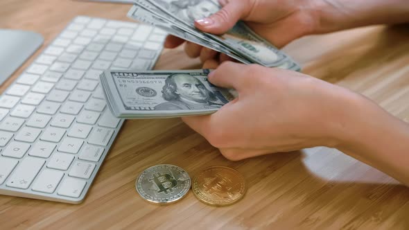 Female Hands Counting Cash with Bitcoins. Crop View of Woman Hands Counting Large Bundle of Dollar