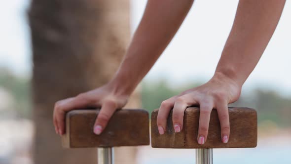 Blonde Gymnastic Woman Leans on the Stands with Her Palms and Performing Exercises