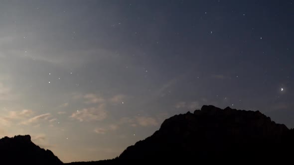 Night time lapse in the Mountains with Clouds and Stars