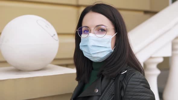 A Girl in a Medical Mask From the Coronavirus in the City Center