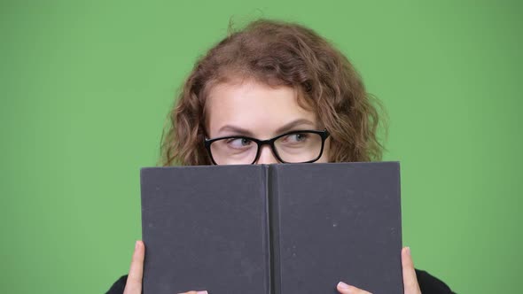 Young Beautiful Nerd Woman Covering Face with Book