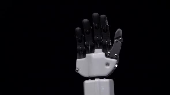 Robot Hand Close Up Waving Bye . Black Background. Close Up. Slow Motion