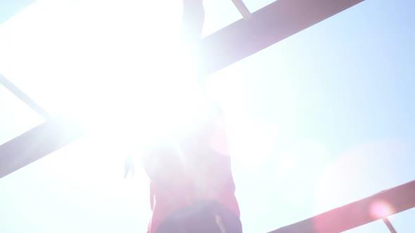 Girl climbing on monkey bar in the boot camp