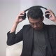 handsome Asian man with glasses hanging headphones around his neck - VideoHive Item for Sale