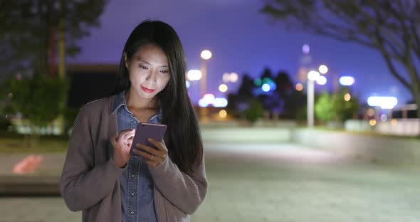 Woman use of smart phone at outdoor in winter time at night