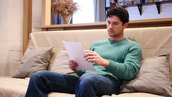 Upset Man Disappointed While Reading Documents Paperwork