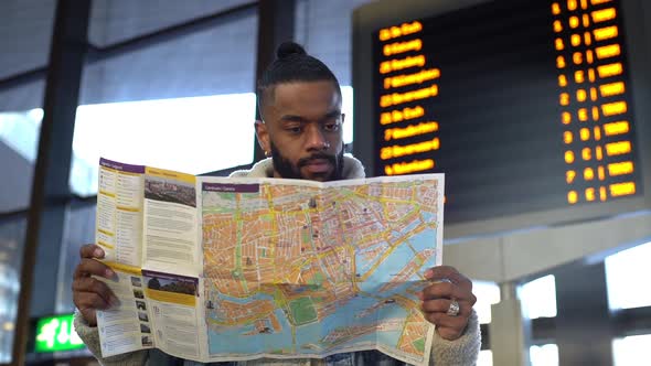 Slowmo Handsome Black Man Traveler Studying City Map Holding Guide Leaflet Smiling Finding Perfect