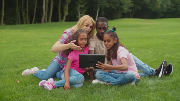 Multiethnic Family Making Video Call on Tablet Pc