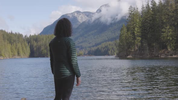 Adventurous Caucasian Woman on the Rocks By the Water in Canadian Nature Landscape