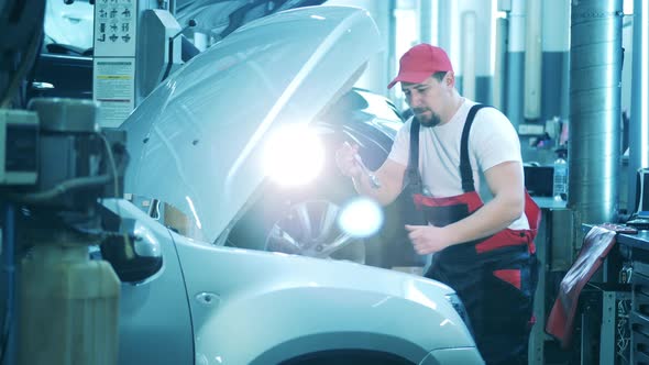 Car Mechanic Uses a Wrench to Repair a Car