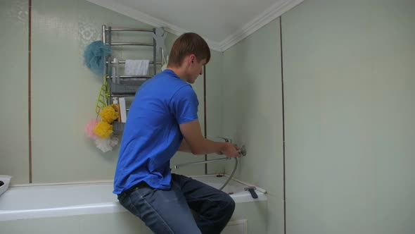 Plumber Installs A Faucet