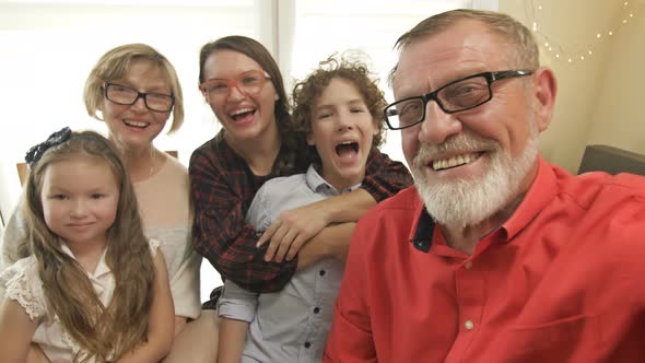 Family Celebrating Christmas Congratulates Someone Via a Video Call From a Computer.