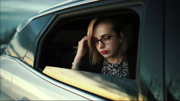 Pretty woman looking out of car, smiling