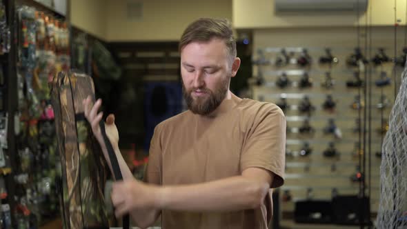 Bearded Man in a Fishing Tackle Shop Getting Ready for a Fishing Trip