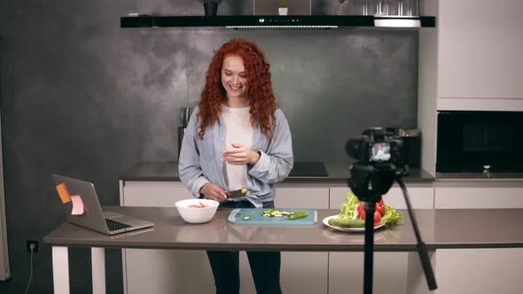 Young Woman in Casual Clothes Leads a Culinary Blog and Records Video in Grey Kitchen's Bar