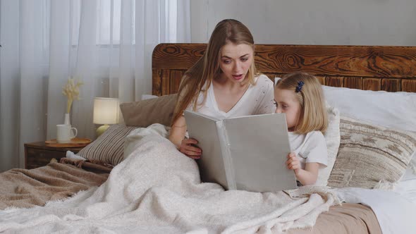 Caucasian Young Adult Single Mother Woman Mom Reading Fairy Tale Book to Beloved Little Daughter