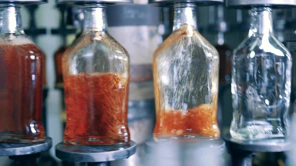 Liquor Is Being Poured Into Glass Bottles By the Conveyor