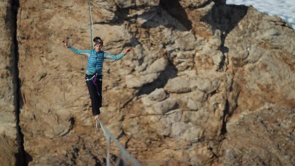 A Young Woman Is on the Slackline at High Altitude