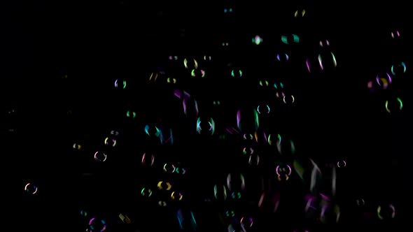 Soap Bubbles Fly and Fade in Different Colors. Black Background