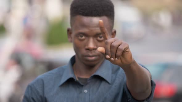 African American man makes "NO" with his finger- outdoor- slow motion