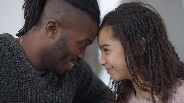 Closeup Side View Faces of Joyful African American Father and Daughter Heads Together Laughing