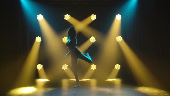 Woman Dancing Modern Dance at Smoky Stage with Spotlights. Vogue or Contemporary Dance. Young Dancer