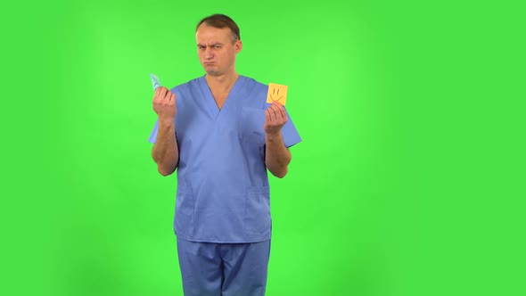 Medical Man Holding Paper Stick Expressing Awful Mood Then Takes Another Expressing Good Mood. Green